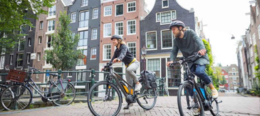 Ein Mann und eine Frau fahren auf e-Bikes durch die Altstadt