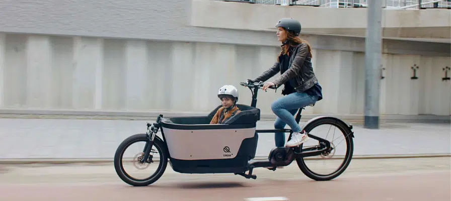 Frau fährt mit Kind im Carqon Cruise Lasten e-Bike